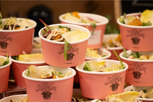 Paper pots of salad laid out along the lunch table.